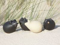 Foto: Vier Keramikmäuse im Strandsand